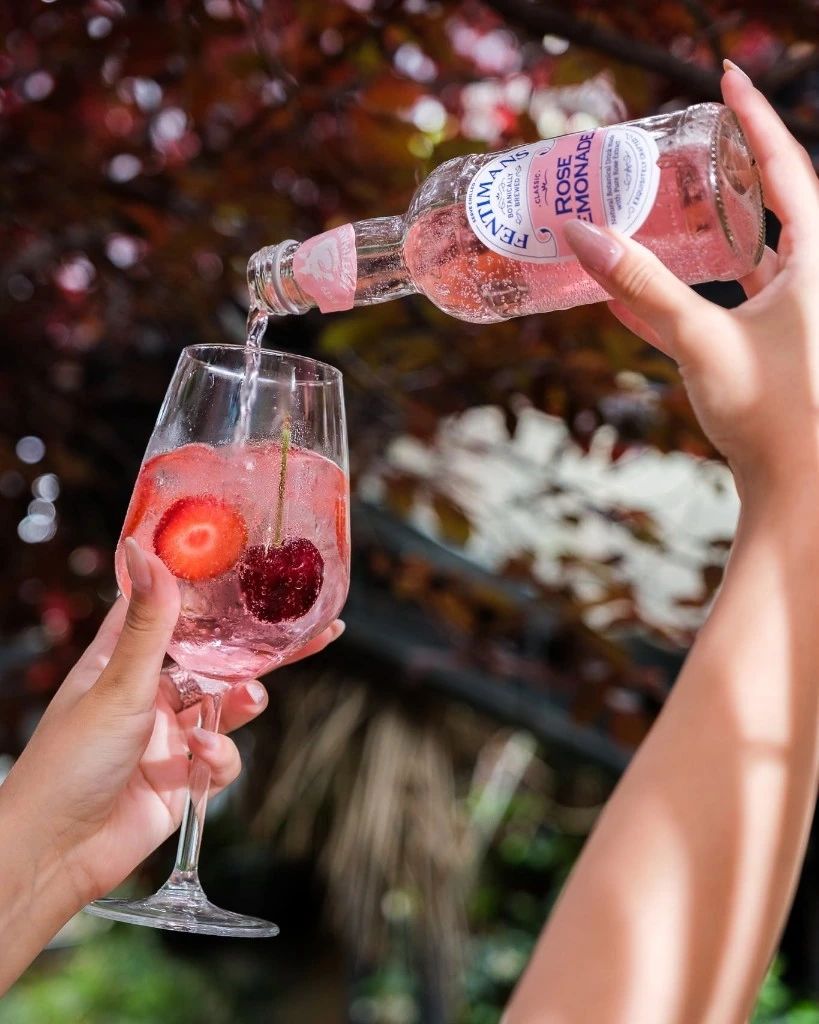 Pouring Fentimans Rose Lemonade over ice