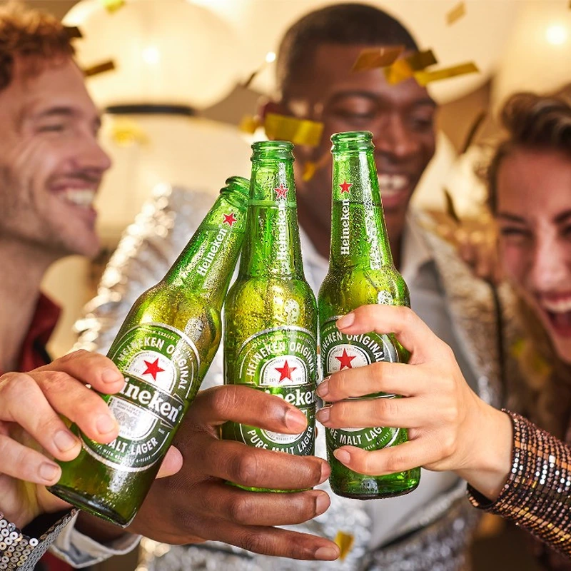 Friends toasting with Heineken bottles at a celebration