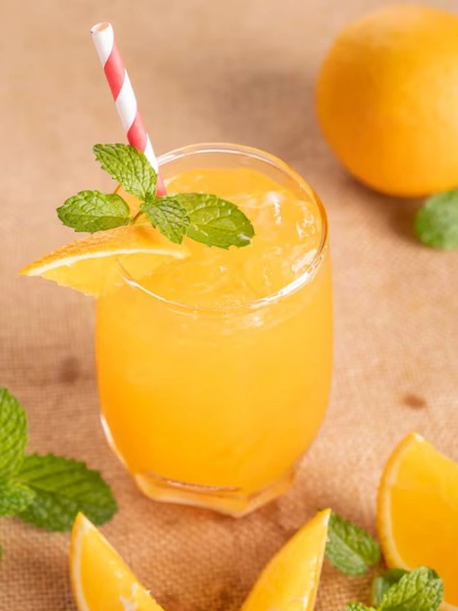 Fresh orange juice in a glass with mint and orange slices