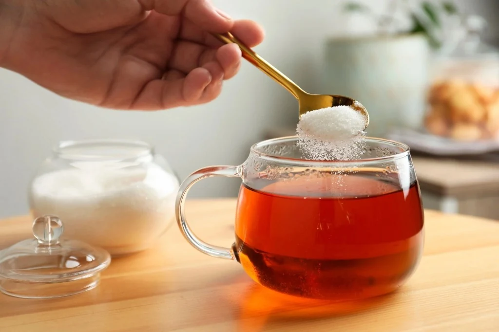 Spoon of sugar sweetening a cup of tea