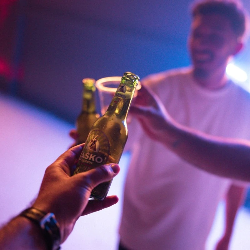 Friends toasting with Laško Zlatorog beer