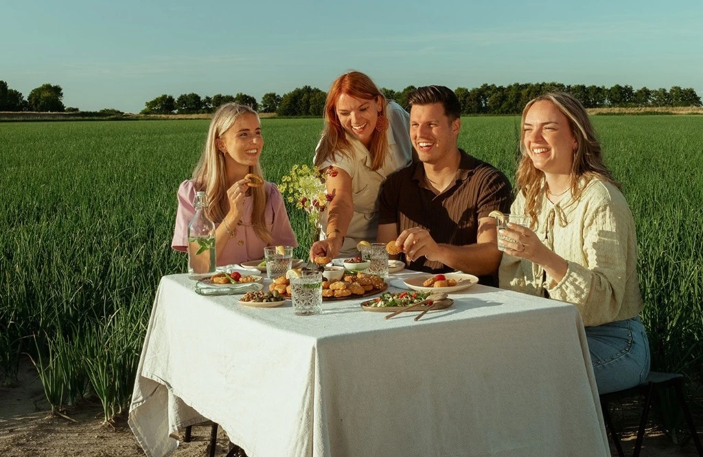 Friends enjoying La Le Duc snacks in an onion field