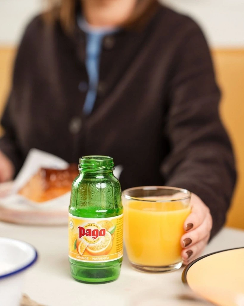 Pago orange juice bottle poured into a glass