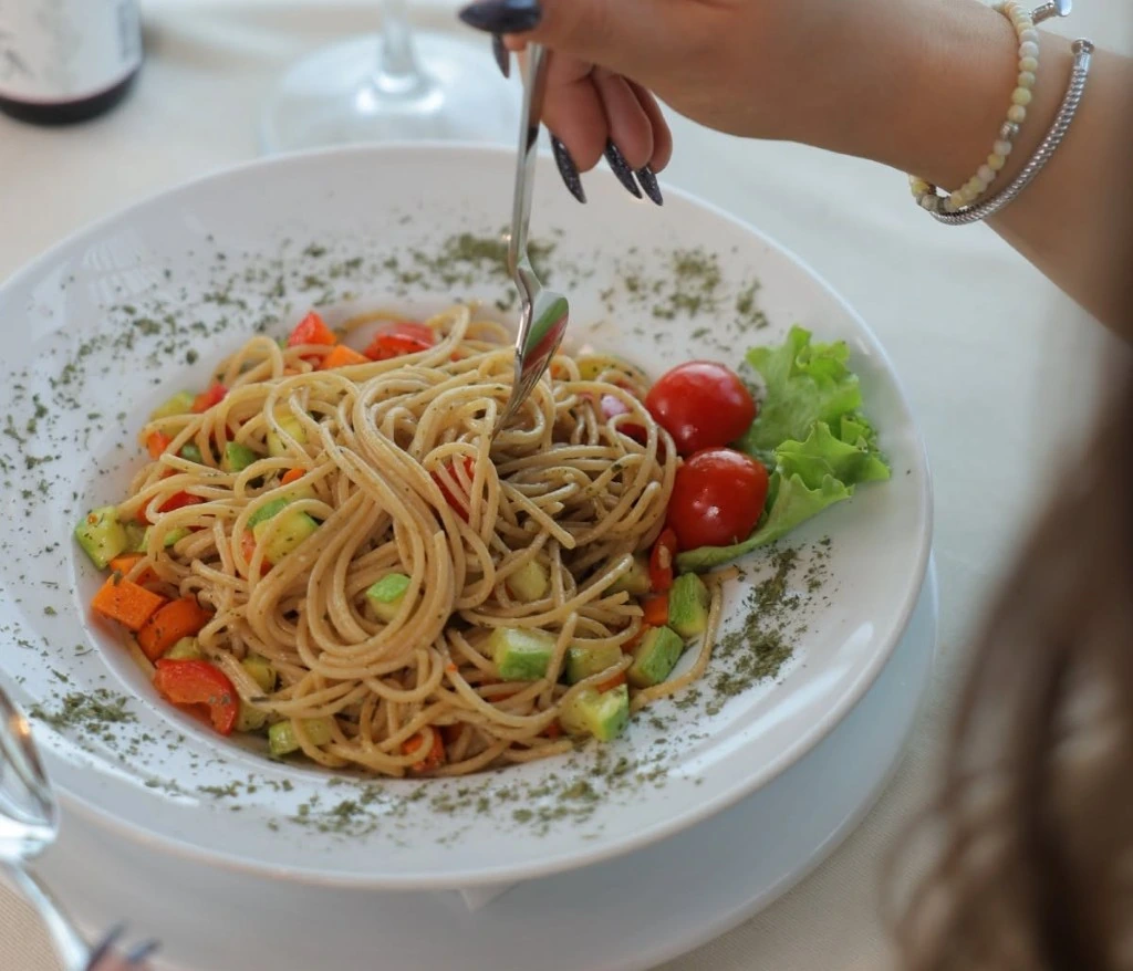 Pantanella pasta with vegetables being twirled on a fork