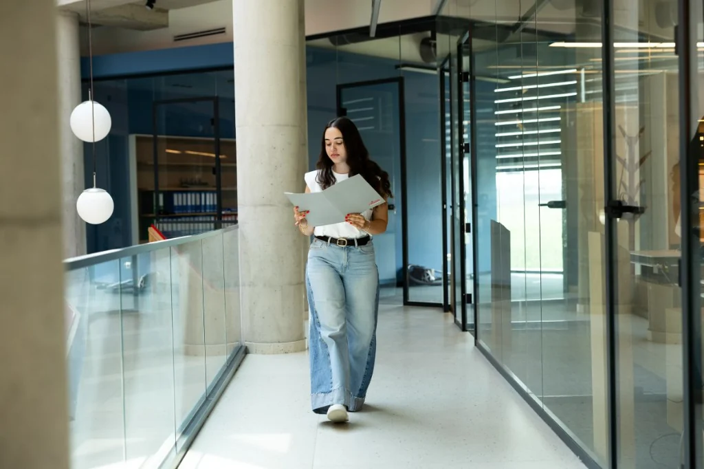 Team member walking through the office with a folder